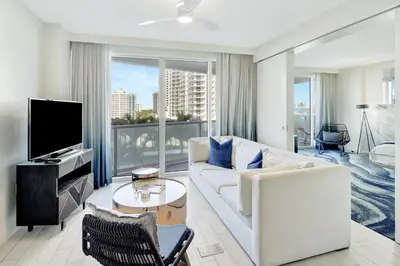 a living room with a white couch and a tv at Beach Club - Oceanfront Luxury, Resort Amenities, Balcony Views in Fort Lauderdale