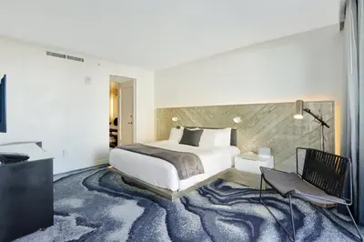 a bedroom with a king sized bed and a carpet at Beach Club - Oceanfront Luxury, Resort Amenities, Balcony Views in Fort Lauderdale