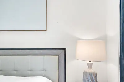 a bedroom with a bed and a lamp next to a mirror at Villa Monaco in Miami Beach