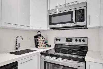 a kitchen with a stove and a microwave at Villa Monaco in Miami Beach