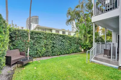 a yard with two benches in front of a hedge at Villa Monaco in Miami Beach