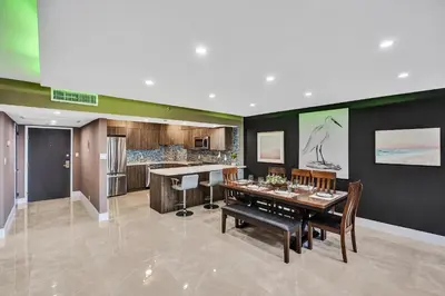 a dining room with a table and a kitchen at Beachside Condo with Resort Amenities, Including Pools, Gym, and Bathtub 503 in Miami Beach