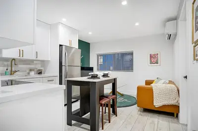 a kitchen with a table and a refrigerator at Tropical Guest House at VIlla Verde Miami in Miami