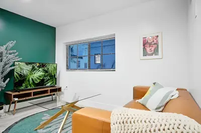 a living room with a couch and a tv at Tropical Guest House at VIlla Verde Miami in Miami