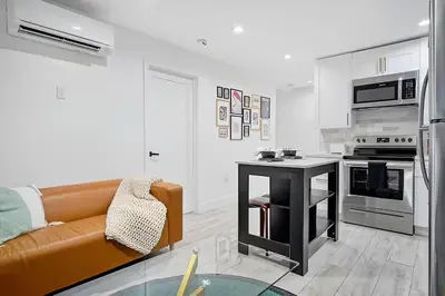 a living room with a couch and a kitchen at Tropical Guest House at VIlla Verde Miami in Miami