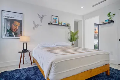 a white bedroom with a large bed and a lamp at Private Suite At Villa Verde Miami in Miami