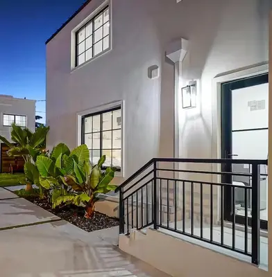 a white house with a black railing and plants at Private Suite At Villa Verde Miami in Miami