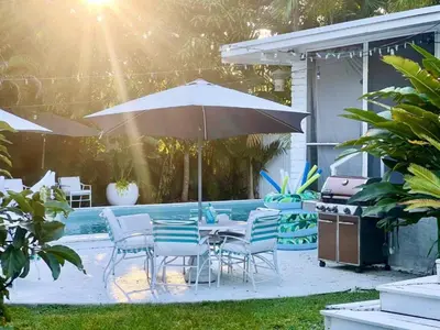 a table and chairs with an umbrella next to a pool at Miami Pool Cottage in Miami