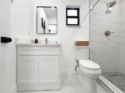 a white bathroom with a toilet and a mirror at Little Havana Paradise in Miami