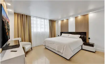a bedroom with a bed and a chair and a television at Luxury Oceanfront 2 Bedroom ON THE BEACH 3 FLOOR in Hollywood