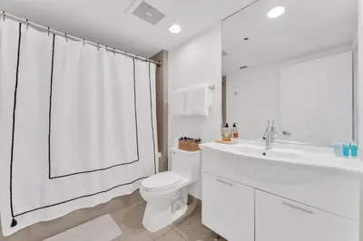 a white bathroom with a toilet and a sink at Luxury Unit W Residences Brickell in Miami