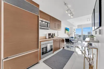 a kitchen with wooden cabinets and a dining room at Luxury Unit W Residences Brickell in Miami