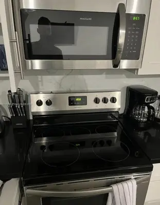 a microwave above a stove in a kitchen at 3BR Townhouse, Miami and the Keys in Homestead