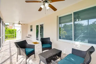 a screened in porch with chairs and a ceiling fan at 8 Mi to Wynwood Waterfront Retreat with Lanai in Miami