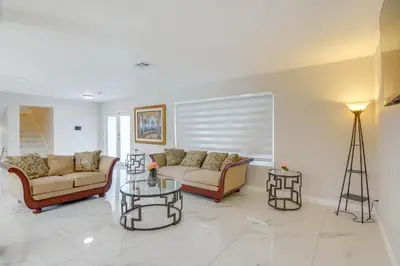a living room with two couches and a table at 8 Mi to Wynwood Waterfront Retreat with Lanai in Miami