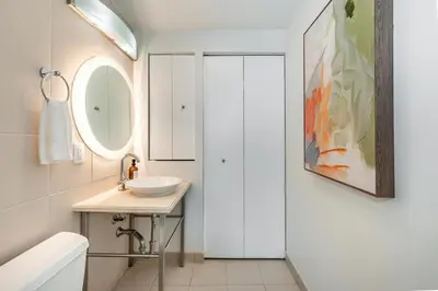 a white bathroom with a sink and a mirror at 2 bedroom Bay View Beauty in Coconut Grove- Parking for 2 cars included! in Miami