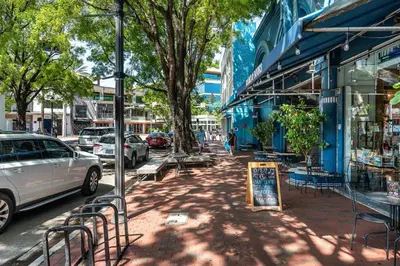 a city street with parked cars and a sign on the sidewalk at Coconut Grove Bayview unit Parking Included in Miami