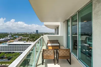a balcony with a table and chairs on a building at Bay View Beauty 1 Bedroom condo in Coconut Grove Parking Included in Miami