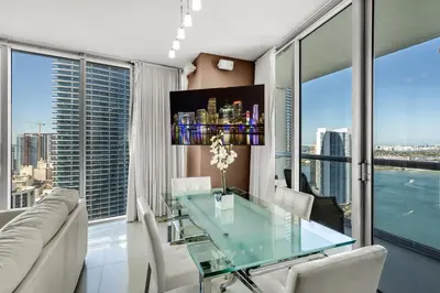 a dining room with a glass table in front of a window at Icon brickell The W hotel residence in Miami