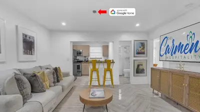 a living room with a couch and a table and yellow stools at Miami Designer Apartment Unit 2 in Miami