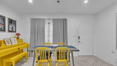 a dining room with a table and yellow chairs at Miami Designer Apartment Unit 2 in Miami