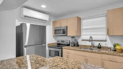 a kitchen with stainless steel appliances and wooden cabinets at Miami Designer Apartment Unit 2 in Miami