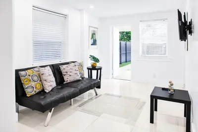 a black couch in a white living room with pillows at Miami Designer Apartment Unit 1 in Miami