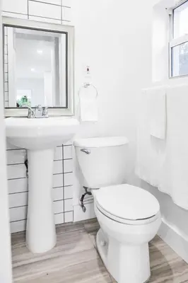 a white bathroom with a toilet and a sink at Miami Designer Apartment Unit 1 in Miami