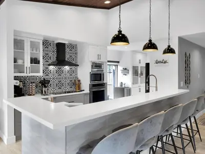 a kitchen with a large white counter and chairs at Tropical Dream House in Plantation 3 Bedroom Home with Pool in Plantation