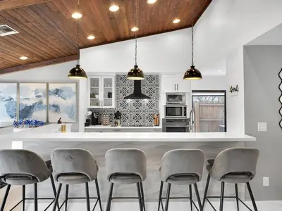 a kitchen with a bar with chairs around it at Tropical Dream House in Plantation 3 Bedroom Home with Pool in Plantation