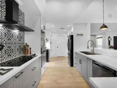 a kitchen with white cabinets and a black refrigerator at Tropical Dream House in Plantation 3 Bedroom Home with Pool in Plantation