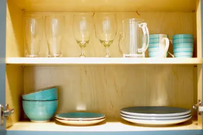 a shelf with glasses and plates and cups and dishes at Spacious Studio heart Of Miami in Miami