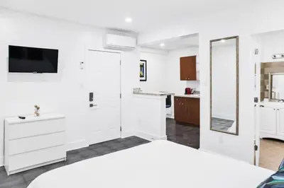 a white bedroom with a large bed and a mirror at Miami Designer Apartment Unit 3 in Miami