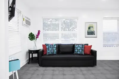 a living room with a black couch and a table at Miami Designer Apartment Unit 4 in Miami