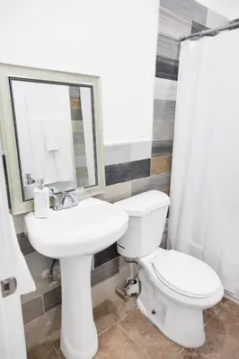 a bathroom with a sink and a toilet and a mirror at Miami Designer Apartment Unit 4 in Miami