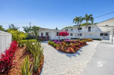 a house with flowers and plants in a driveway at Chic 1-BD Apt in Miami Gym, BBQ, Free Parking in Miami