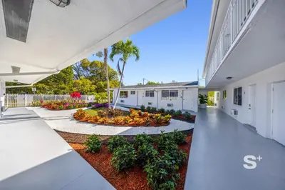 an exterior view of a white building with a courtyard at Miami Retreat - 1-BR Parking, Gym & BBQ Area in Miami