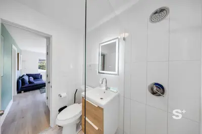 a white bathroom with a toilet and a sink at Miami Retreat - 1-BR Parking, Gym & BBQ Area in Miami