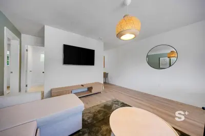 a living room with a table and a tv on a wall at Sleek 1-BD Miami Apt Gym, BBQ, Free Parking in Miami