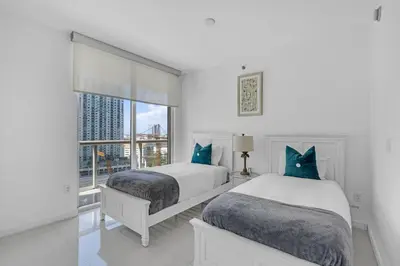 two beds in a white room with a window at Moderne 2 bed 2 bath Residence in Miami