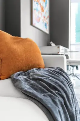 an orange pillow on a white couch with a table at Icon brickell 1 bed 1 bath residence in Miami