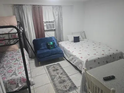 a bedroom with a bed and a blue chair at Land of the free in Miami