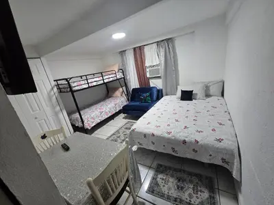 a small bedroom with a bed and a chair at Land of the free in Miami