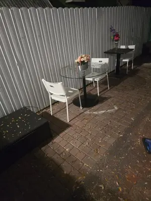 two chairs and a table and a table and a fence at Land of the free in Miami