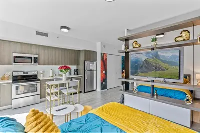a living room with a blue couch and a kitchen at Miami Penthouse Infinity Pool in Miami