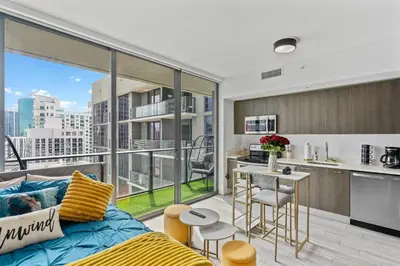 a living room with a couch and a large window at Miami Penthouse Infinity Pool in Miami