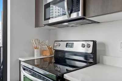 a kitchen with a stove and a microwave at Miami Penthouse Infinity Pool in Miami