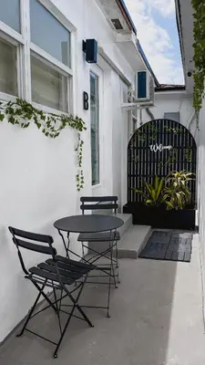 a patio with two chairs and a table in front of a building at Cozy Miami Suite with FREE Parking in Miami