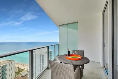 a balcony with a table and chairs and the ocean at LYFE, Rent Excelent Apartment in Resort, 4Pax ,Parcial Ocean View in Hollywood