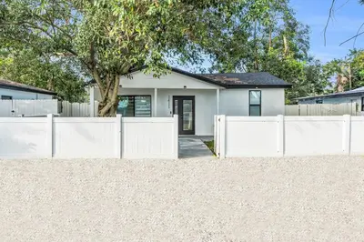 a white fence in front of a white house at Modern Home with large private yard - Next to downtown & beach & airport - Pet friendly in Fort Lauderdale